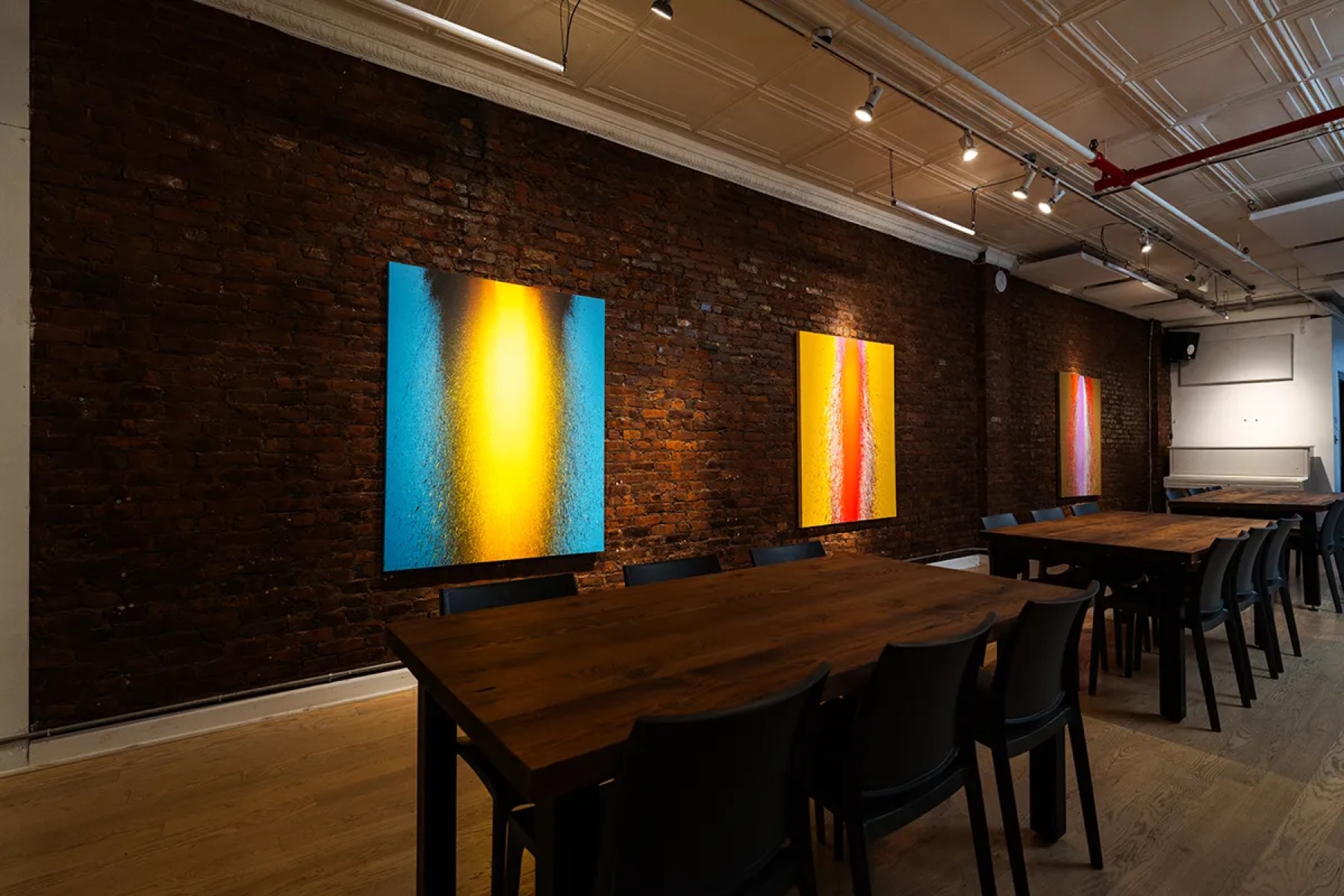 Long dinner tables under hanging art